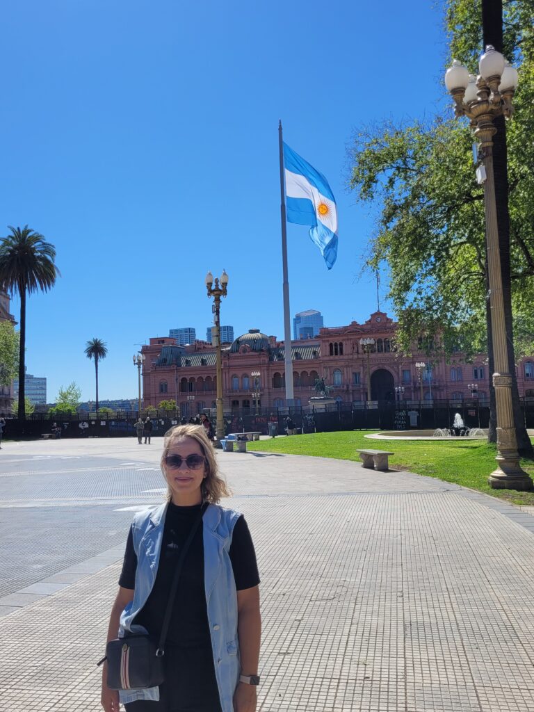Mulher em frente à Casa Rosada com Bandeira da Argentina