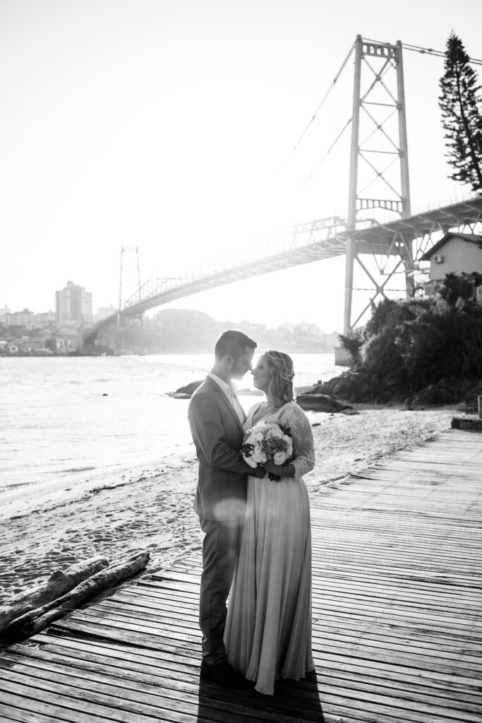 Casal de noivos com a ponte Hercílio Luz de fundo