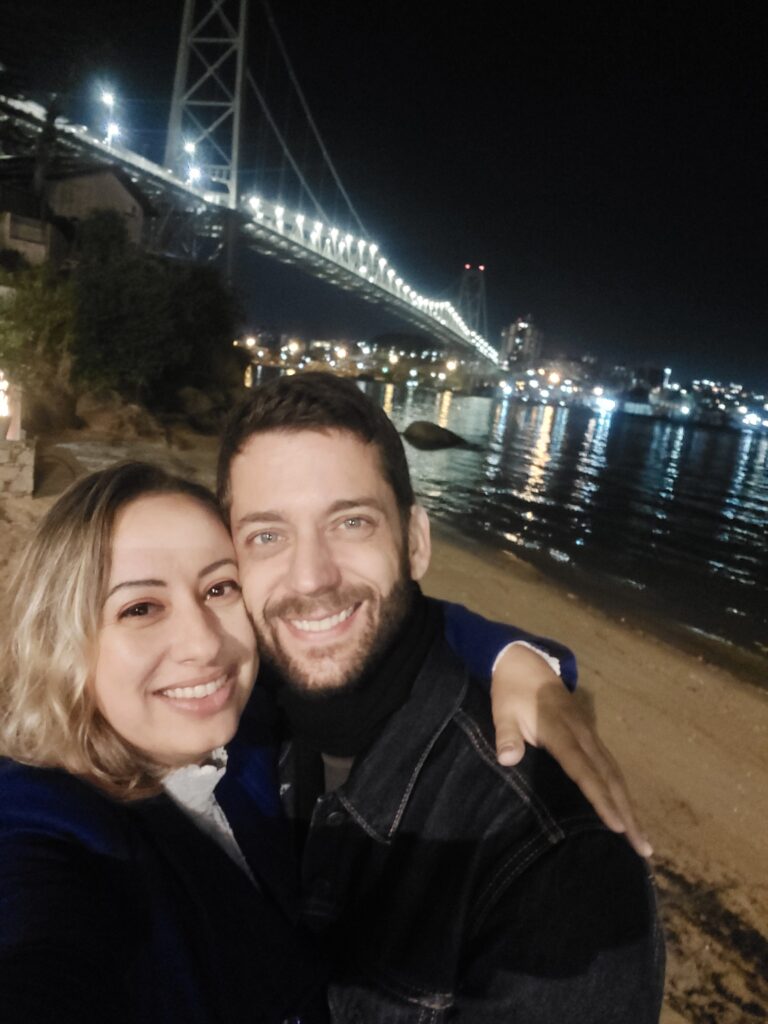 Casal com a ponte Hercílio Luz iluminada de fundo