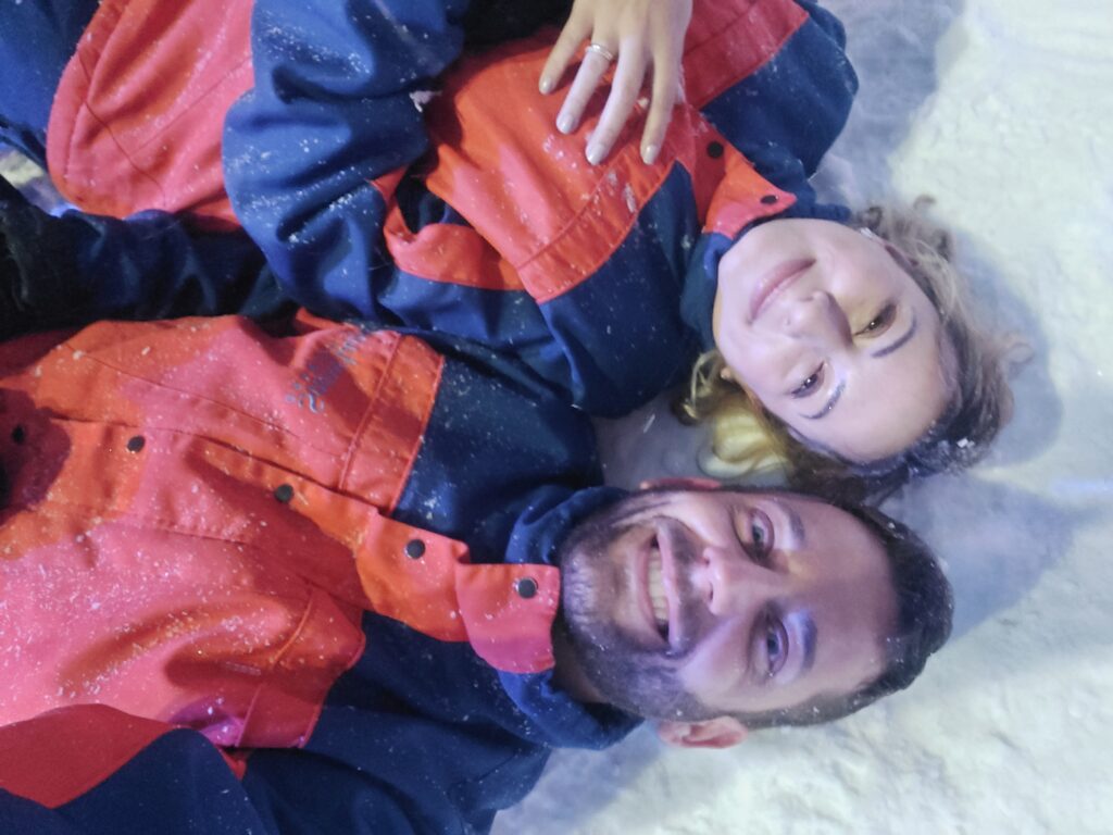 Casal deitado na neve na Snowland em Gramado